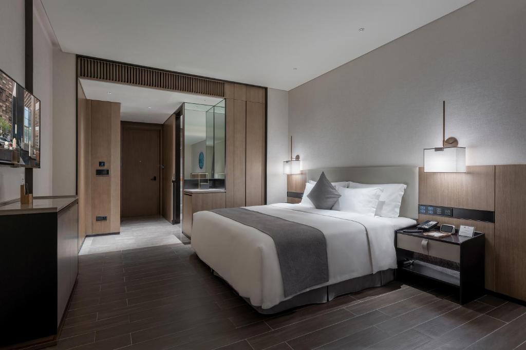 Postel nebo postele na pokoji v ubytování Genpla Hotel, Shenzhen Qianhai