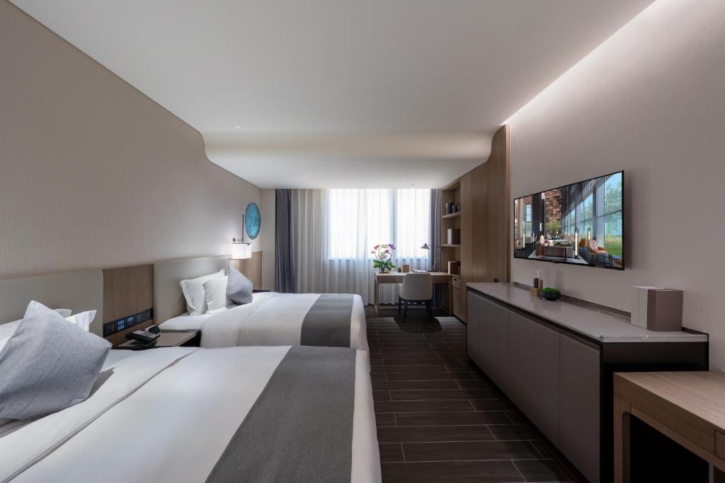 Postel nebo postele na pokoji v ubytování Genpla Hotel, Shenzhen Qianhai