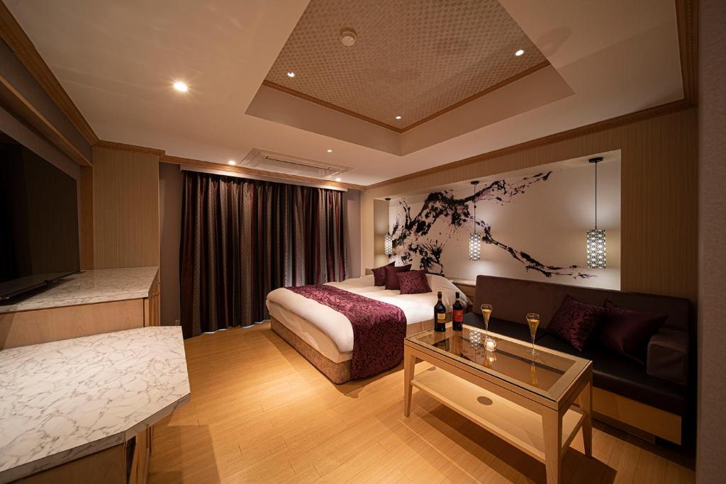 彦根市にあるホテル リッド 男塾ホテルグループのベッドとソファ付きのホテルルーム