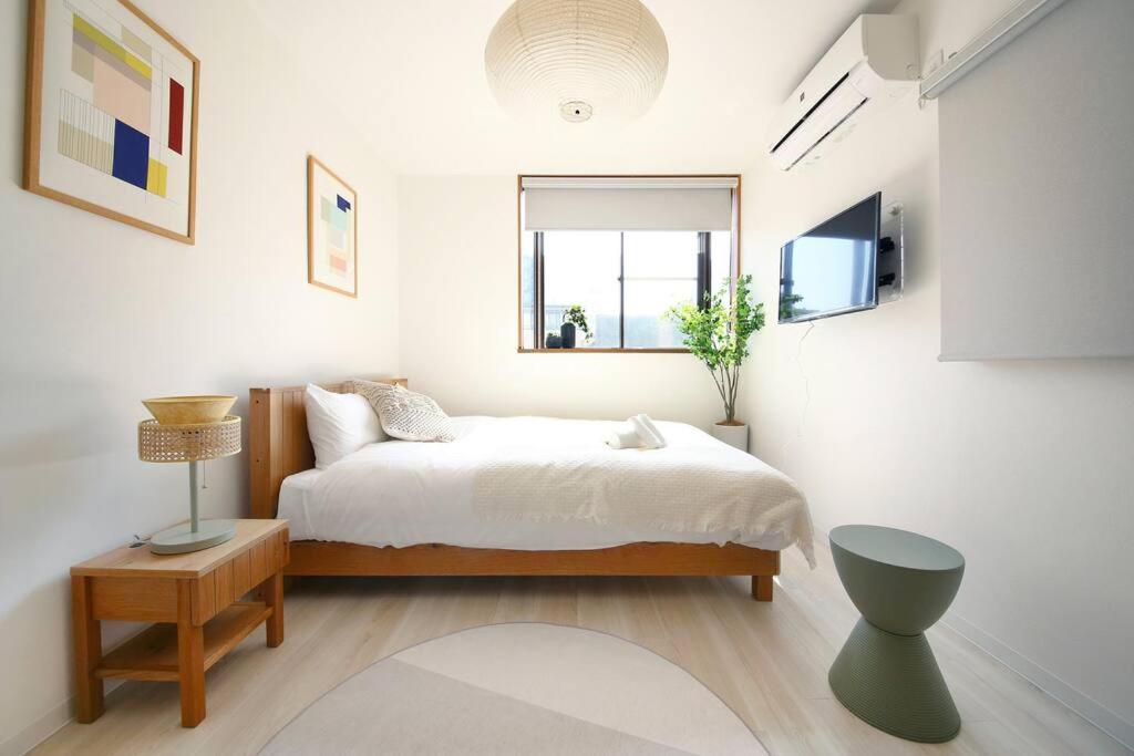 a white bedroom with a bed and a window at Pirane House 201 東京スカイツリー浅草 押上駅が徒歩圏内 無料wifi in Tokyo