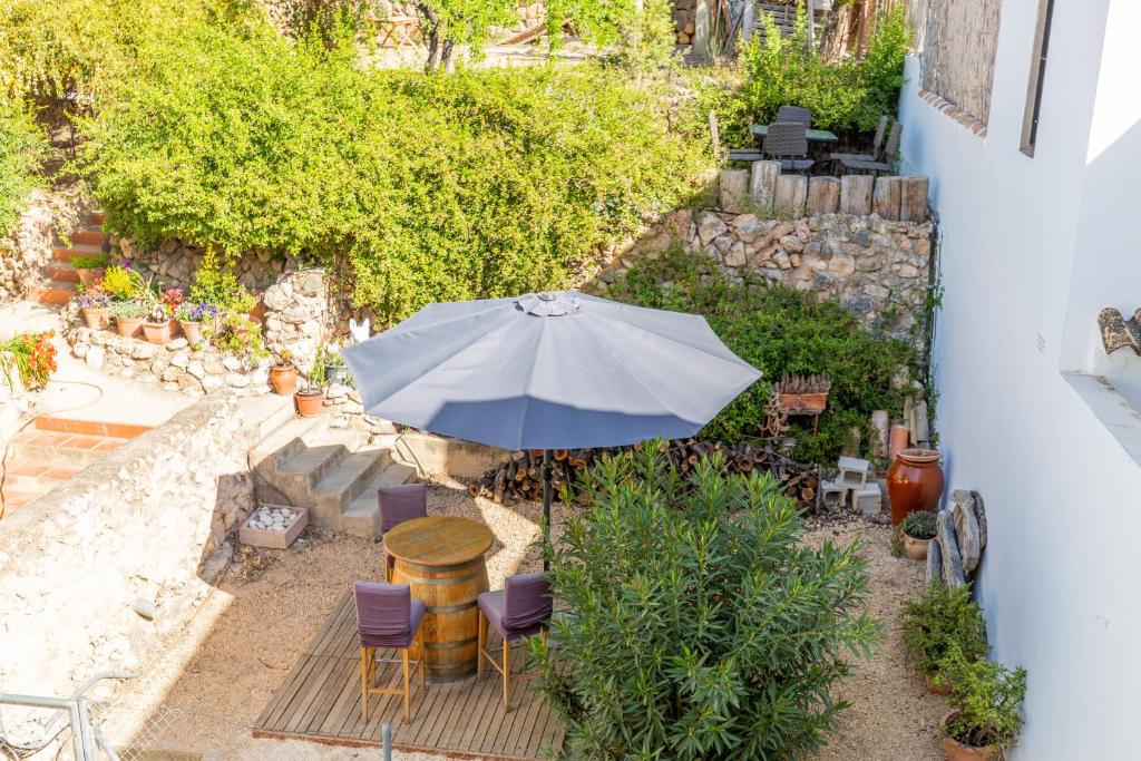 a patio with a table and an umbrella at La Cambra de la Clau in Polop