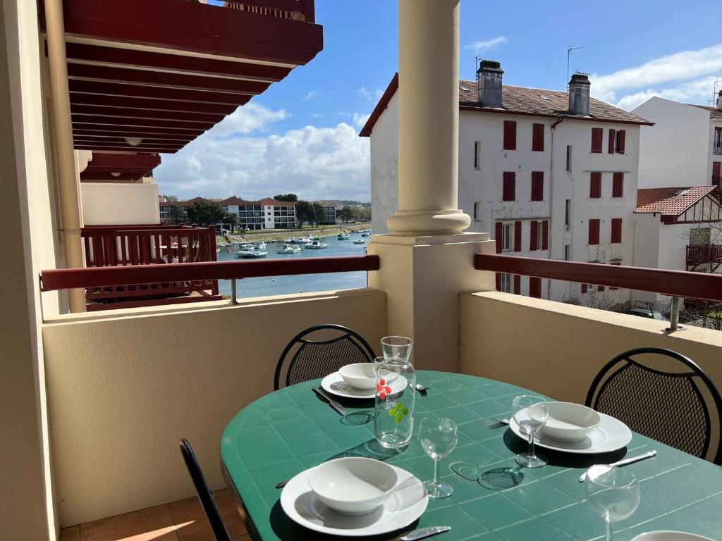 een tafel met borden en glazen op een balkon bij Appartement Ciboure, 3 pièces, 4 personnes - FR-1-239-895 in Ciboure