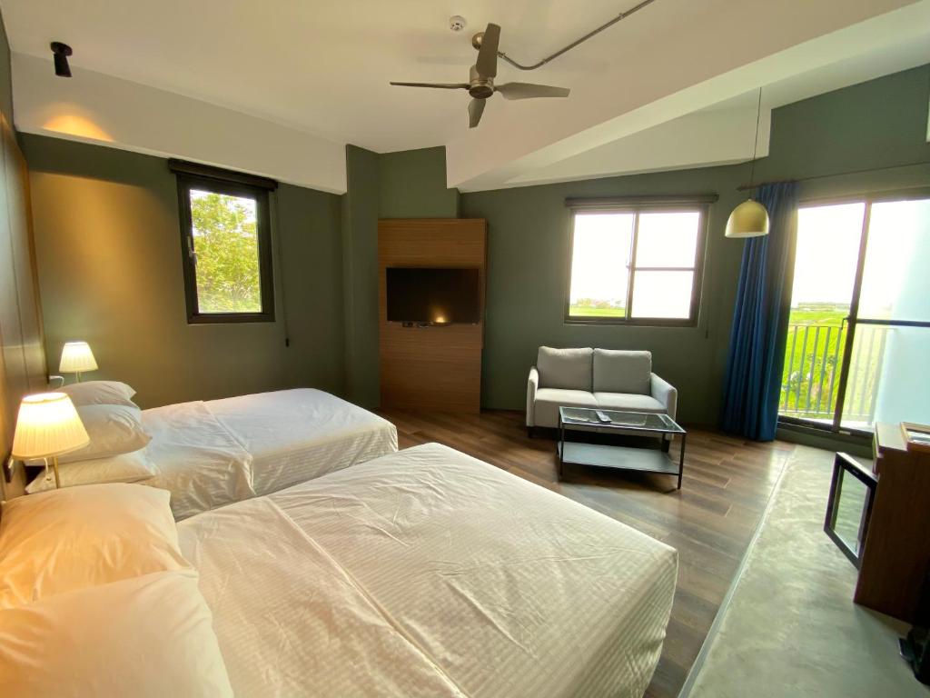1 dormitorio con 2 camas, sofá y ventanas en 木木宿宿MUMUsusu-stay只接待成年者一無包棟服務, en Taitung