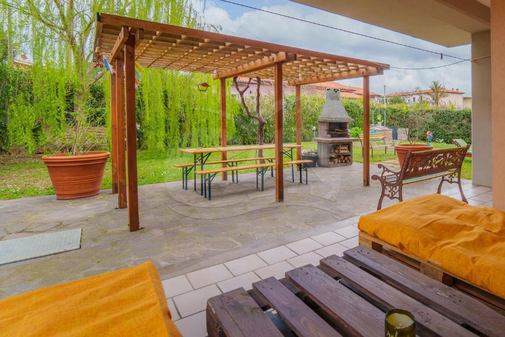 a patio with a table and benches and a grill at A Casa di Zaira - Goelba in Portoferraio