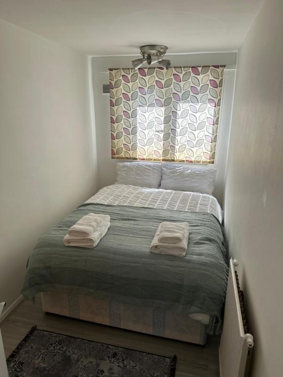 a small bedroom with a bed with two towels on it at Spacious Double room for single room in London