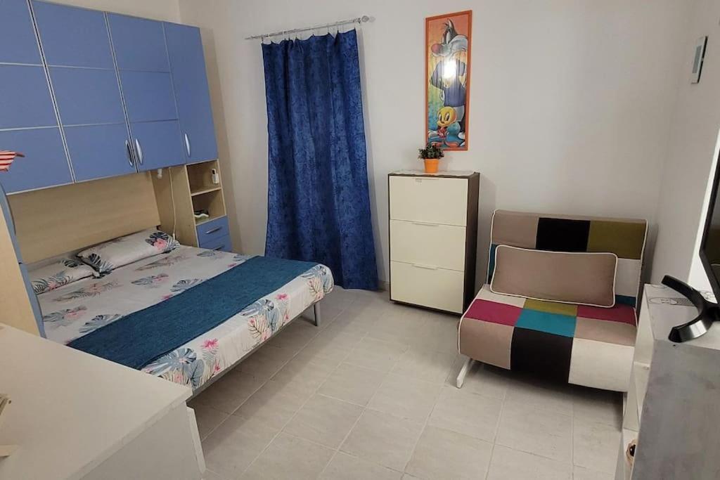 ein Schlafzimmer mit einem Bett und einem Stuhl darin in der Unterkunft Bilocale nel cuore di Sanremo in Sanremo