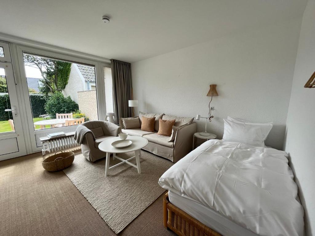 een slaapkamer met een bed en een woonkamer bij Haus Janus 3 - Wohnung 2 in Norderney