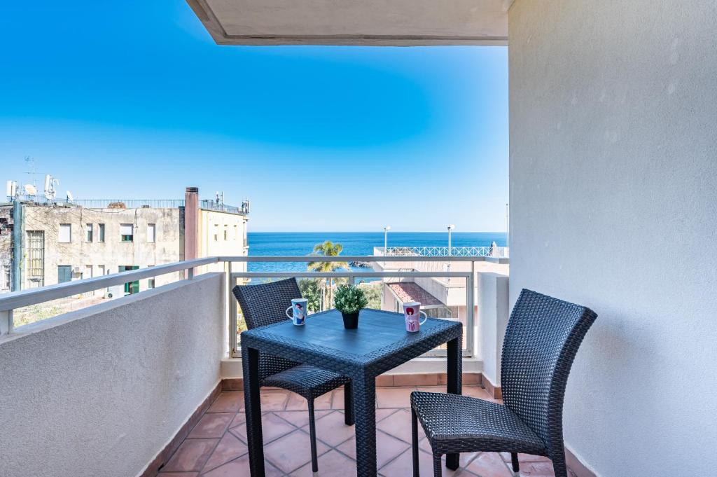 uma mesa numa varanda com vista para o oceano em Lovely Flat with Balcony and Private Parking em Aci Castello