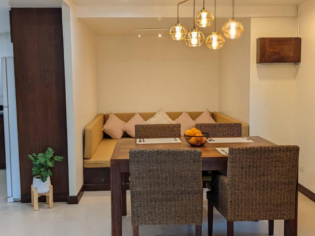 una sala da pranzo con tavolo e divano di The Sands beach apartment a Nai Harn Beach