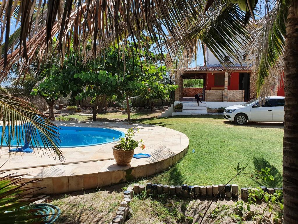 un patio trasero con piscina y una casa en Pousada Aymara, en Ponta do Mel
