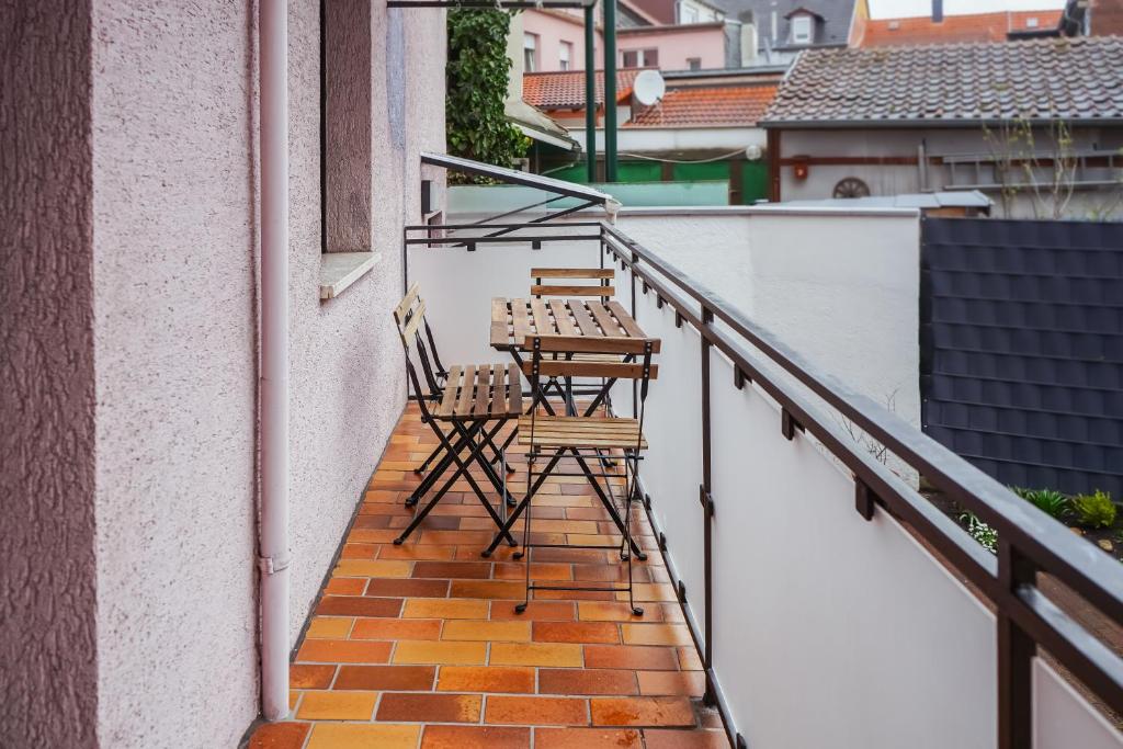 zwei Stühle auf dem Balkon eines Gebäudes in der Unterkunft Zentrales 7Seas Apartment Kaiserslautern - Balkon l 4 Pers l Self Check-in in Kaiserslautern