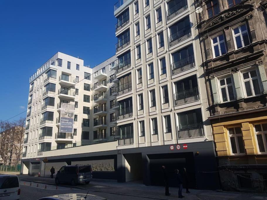 un gran edificio blanco con gente parada frente a él en Harry’s Apartment/centrum/parking, en Wroclaw