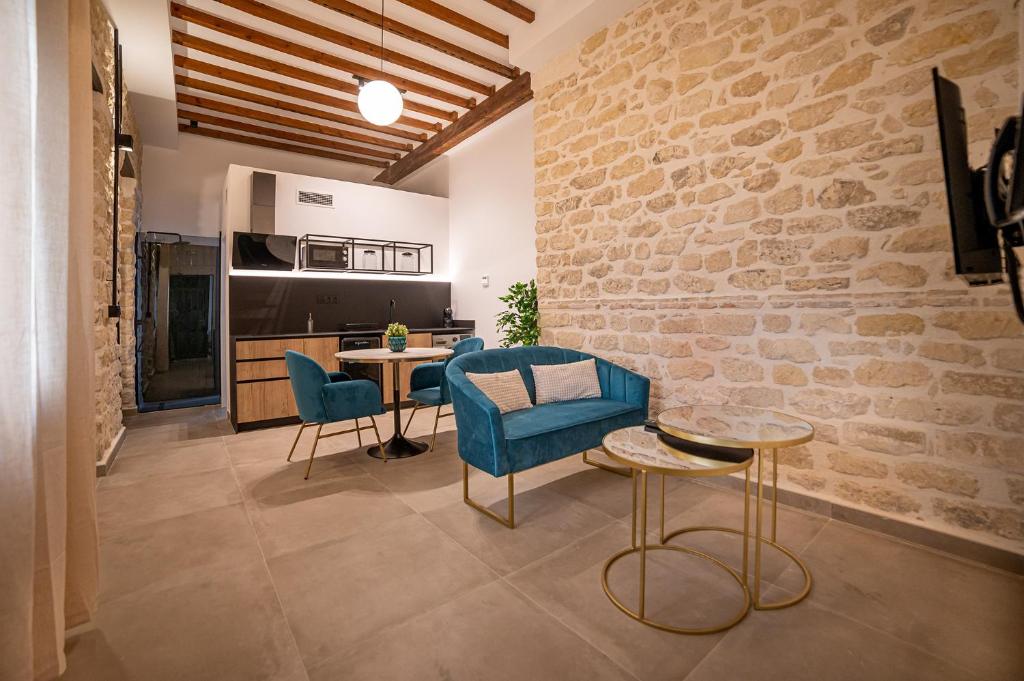a living room with a table and chairs and a brick wall at Apartamentos Loliqui centro Alicante in Alicante