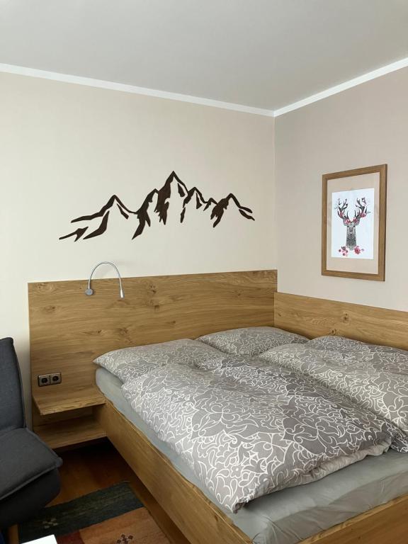 ein Schlafzimmer mit einem Bett mit Bergen an der Wand in der Unterkunft Apartment.Kirche in Sankt Georgen ob Murau