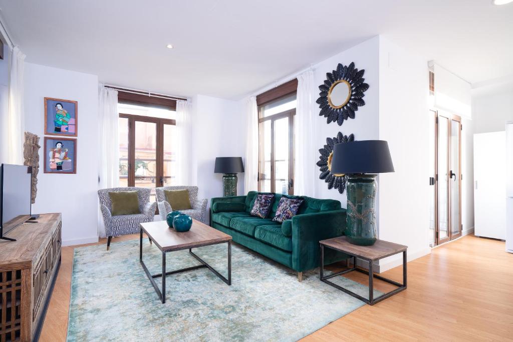 a living room with a green couch and a table at Valencia Luxury - Boutique Market in Valencia