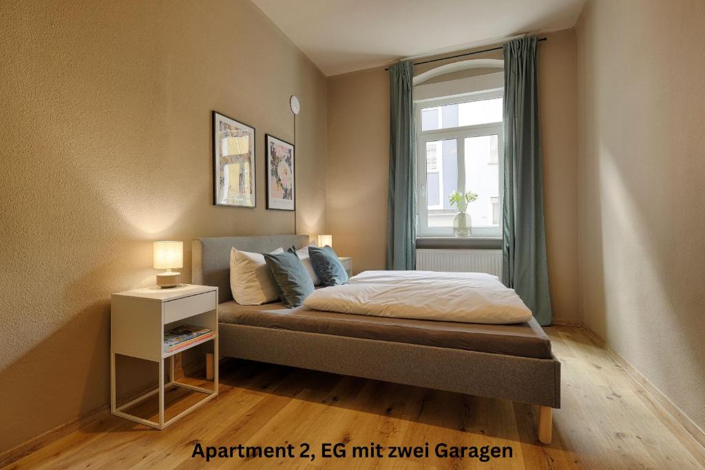 1 dormitorio con cama y ventana en Moderne Altbauapartments, Nahe Stadtzentrum & Weinberge, en Würzburg
