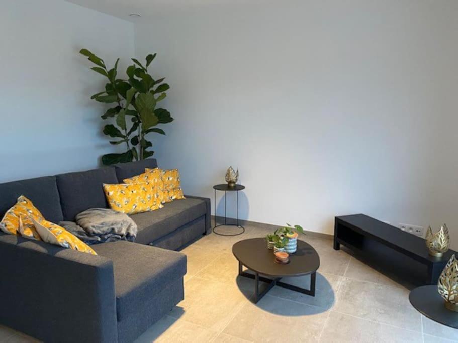 a living room with a couch and a table at Ruim gezellig appartement Zwalm in Zwalm