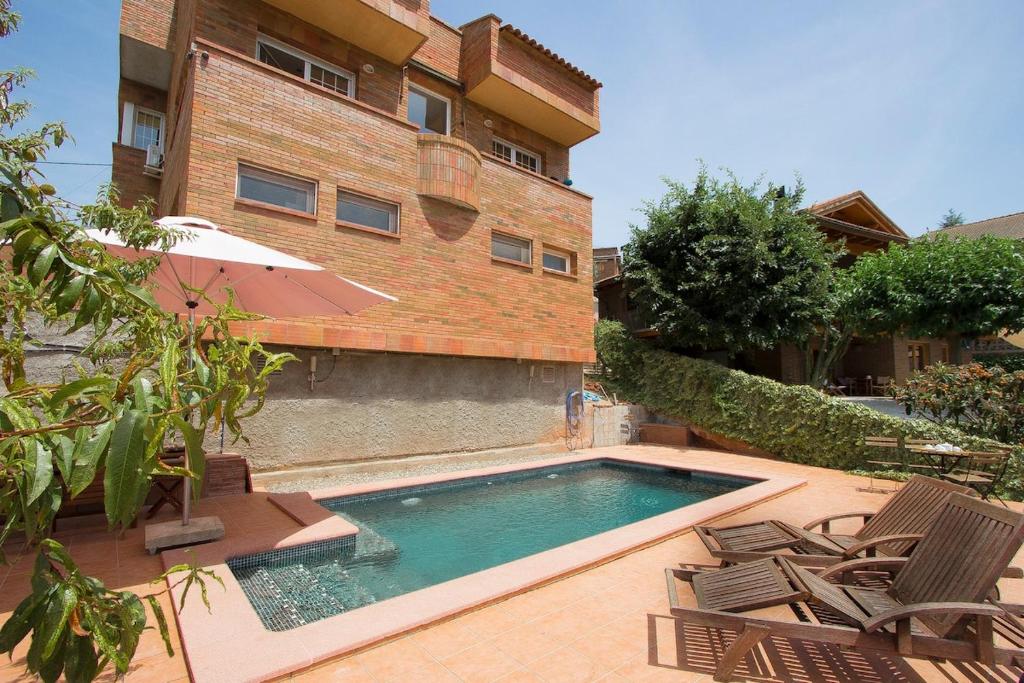 a swimming pool in front of a building at Catalunya Casas Nature & Tranquility only 25kms from Barcelona in Torrelles de Llobregat