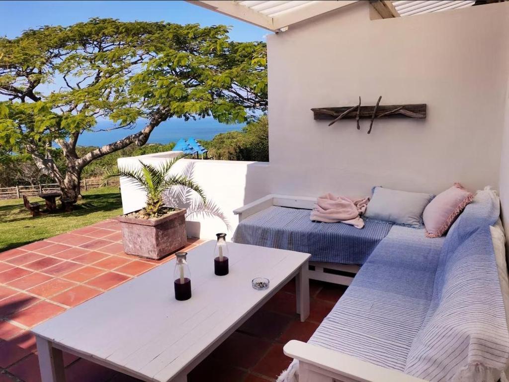 a patio with a table and a couch and a table at Schafli Manor Wild Coast in Chintsa