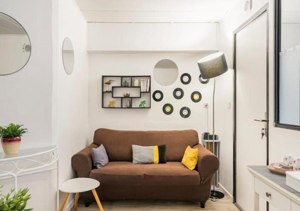 a living room with a brown couch and a table at Chambres privées dans maison avec jardin-Proche LDLC-Groupama Stadium-Eurexpo in Vaulx-en-Velin