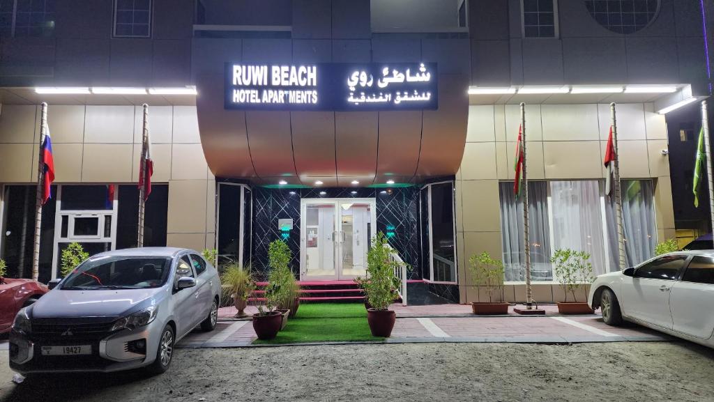 um edifício com carros estacionados em frente em Ruwi Beach Hotel Apartments - MAHA HOSPITALITY GROUP em Sharjah