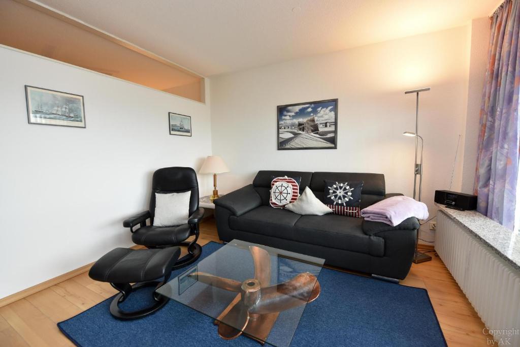 a living room with a couch and a chair at Haus "Panorama" Appartement PAN087 in Duhnen
