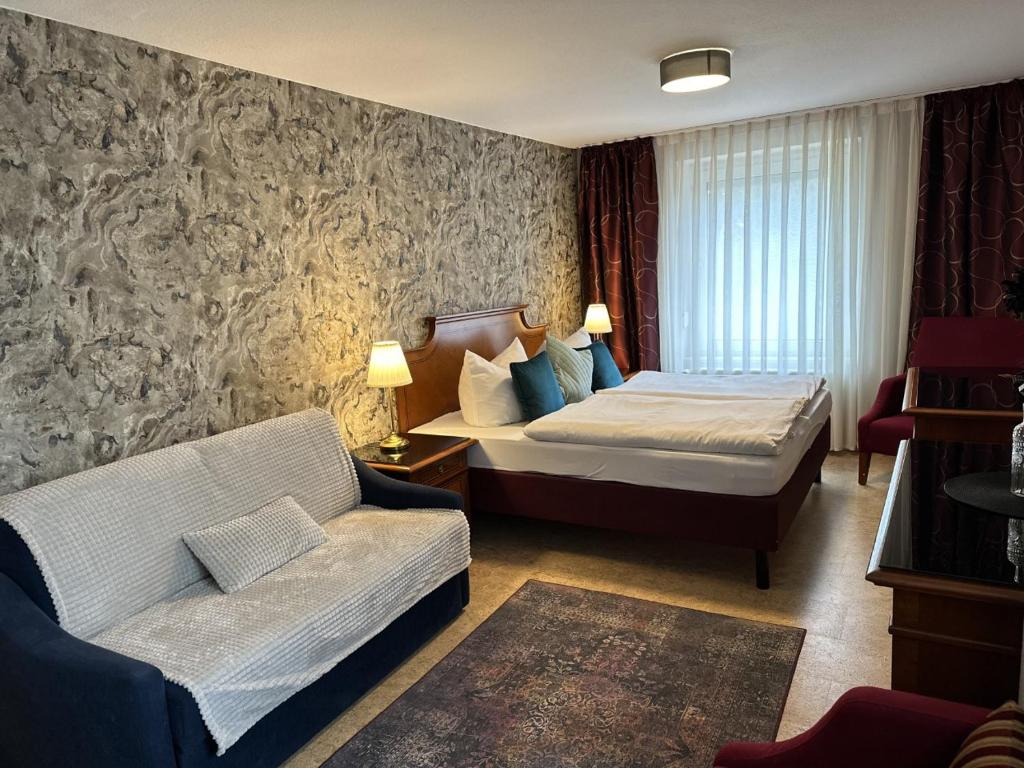 a hotel room with a bed and a couch at Gasthaus AFINA in Süsel
