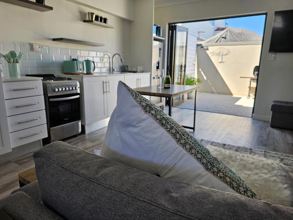 a living room with a couch and a table at Corner Cottage in Cape Town