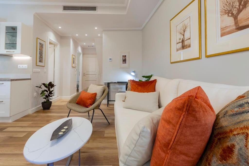 uma sala de estar com um sofá branco e uma mesa em Marisol em Corfu Town