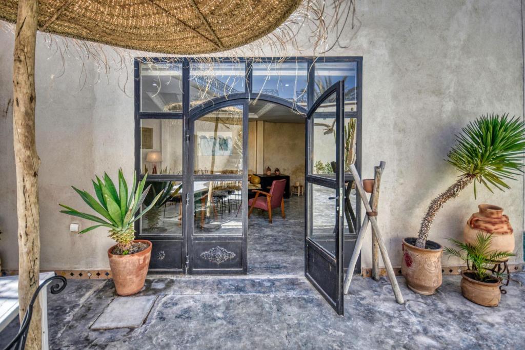 Riad Amazine - Piscine - Rooftop - 6 or 7 Px في أغادير: باب مفتوح مع نباتات الفخار في الغرفة