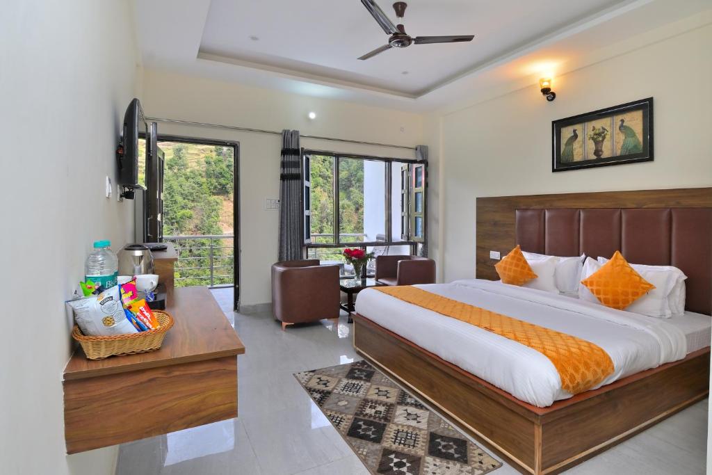 a bedroom with a large bed and a desk at Dhanolti View By LA Riqueza - Centrally Located - Lift & Parking Facility in Dhanaulti