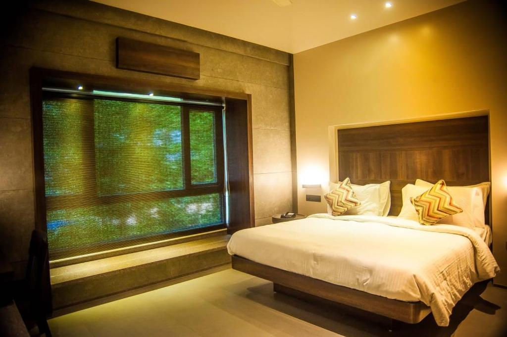 a bedroom with a large bed and a window at SANKAMA The Boutique Hotel in Dāvangere