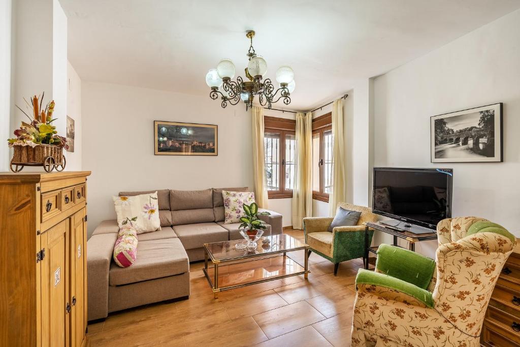 ein Wohnzimmer mit einem Sofa und einem TV in der Unterkunft Casilla de Adela in Albuñuelas