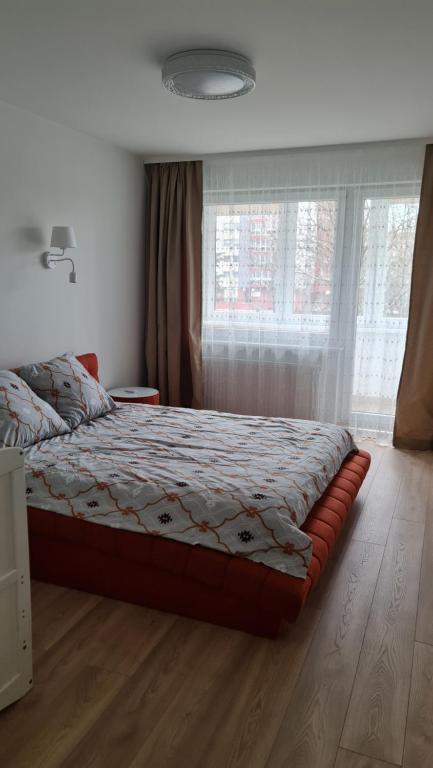 Ce lit se trouve dans une chambre dotée d'une grande fenêtre. dans l'établissement Jaukūs namai-Home Sweet Home, à Klaipėda