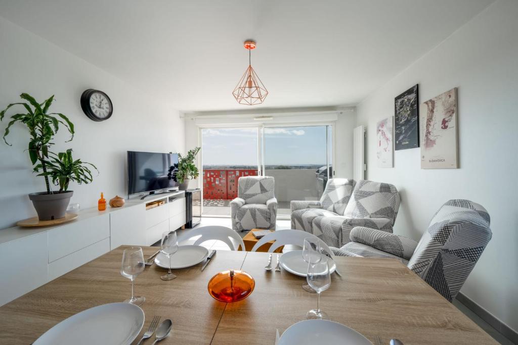 - une salle à manger et un salon avec une table et des chaises dans l'établissement Large and bright nest with a clear view of the sea, à Montpellier