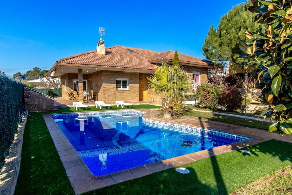 a swimming pool in front of a house at Catalunya Casas Unique Costa Brava Abode with train access to BCN in Sils