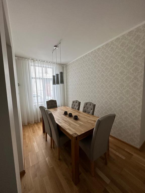 uma sala de jantar com uma mesa de madeira e cadeiras em Apartment Kesklinna läheduses em Tartu