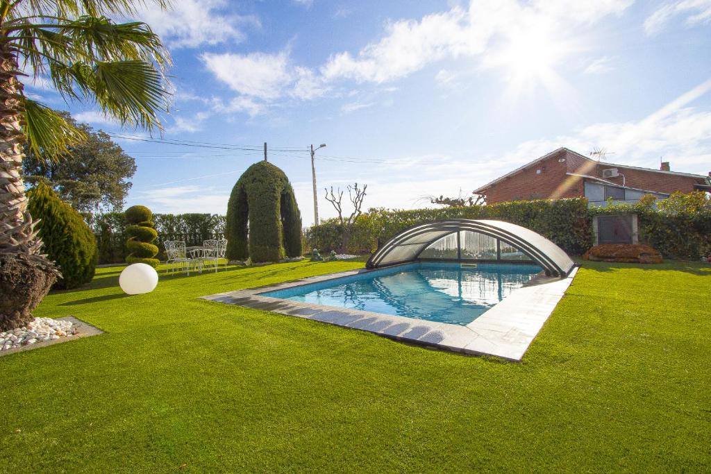 um jardim com uma piscina e uma ponte em Catalunya Casas A Cozy Catalan hideaway just 30min from Sitges! em Piera