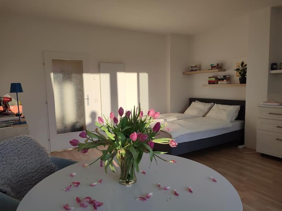 Una habitación con una mesa con un jarrón de flores. en Studio mit Terrasse in zentraler Lage, en Graz