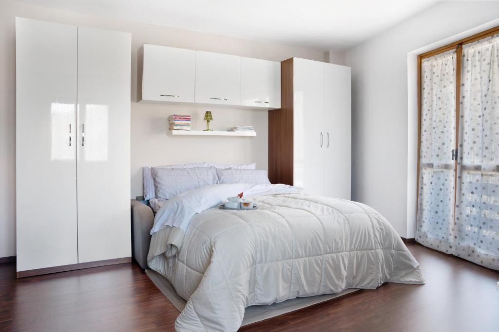 ein weißes Schlafzimmer mit einem Bett und weißen Schränken in der Unterkunft Lurisia in Roccaforte Mondovì