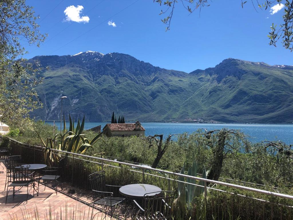 a view of a lake with tables and chairs at Hotel Locanda Ruscello Garnì in Limone sul Garda