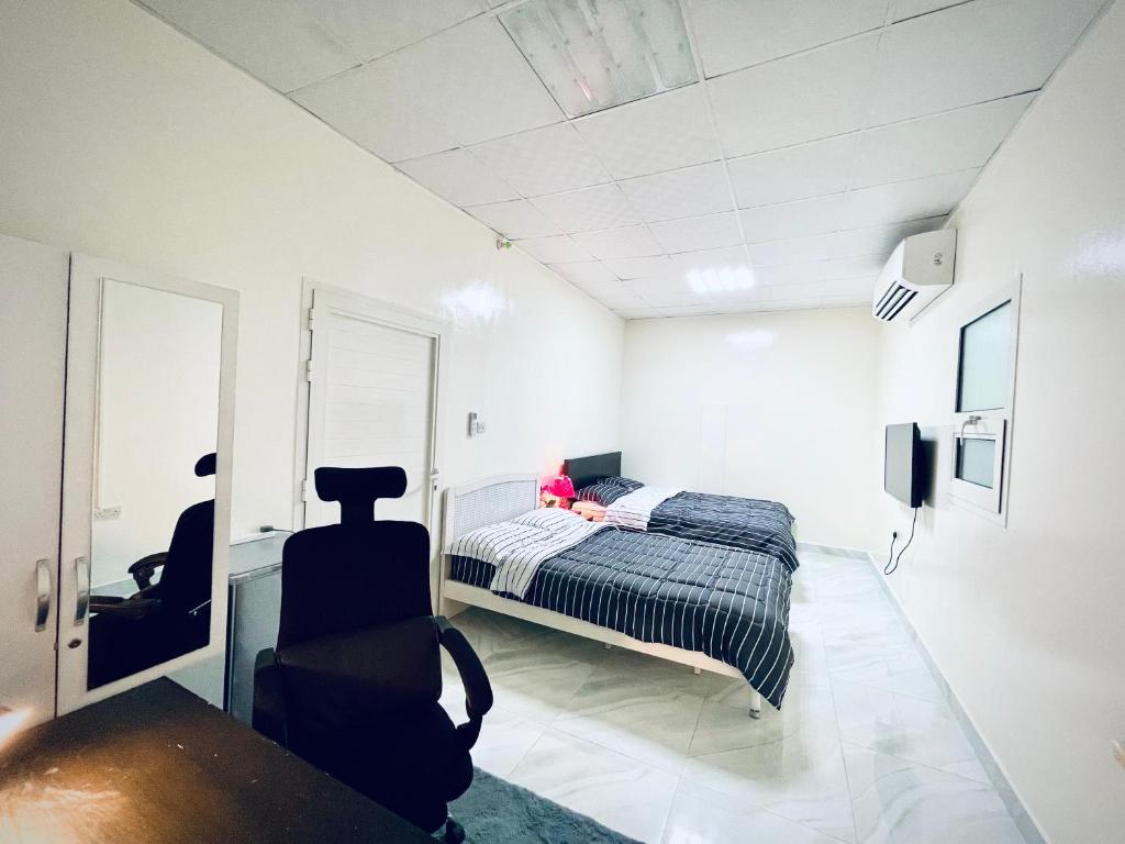 una camera da letto con una ragazza seduta sopra di Private 2Bedroom Villa with T&B and Kitchenette near Abu Dhabi International Airport a Abu Dhabi