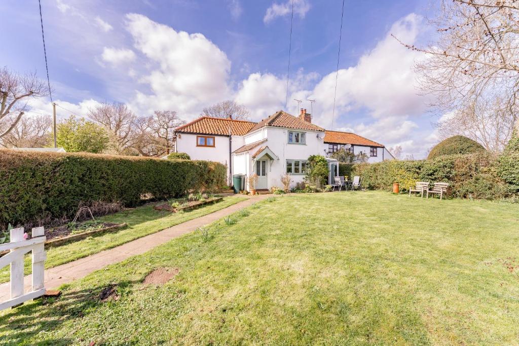 una gran casa blanca con un patio de césped en Bar Lane Cottage - Norfolk Cottage Agency en Reepham