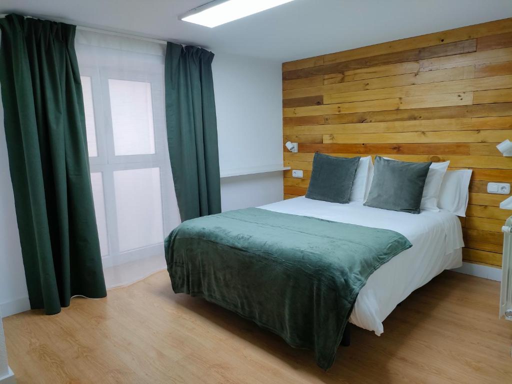 1 dormitorio con 1 cama con cabecero de madera en La Paz, en Almansa