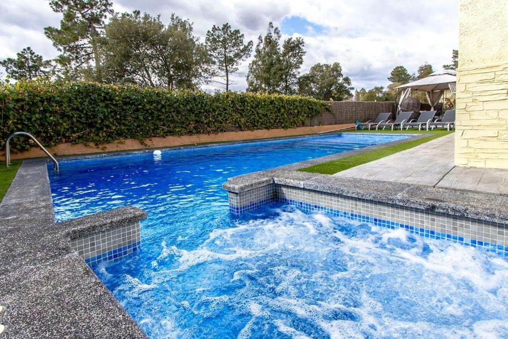 a swimming pool with blue water in a backyard at Catalunya Casas Unique Costa Brava Abode with train access to BCN in Santa Coloma de Farners