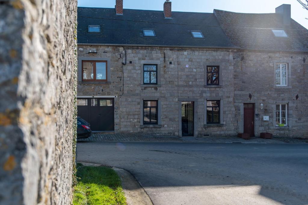 un viejo edificio de ladrillo con un coche aparcado delante de él en Maison de vacances Le Vieux Marronnier, en Dinant