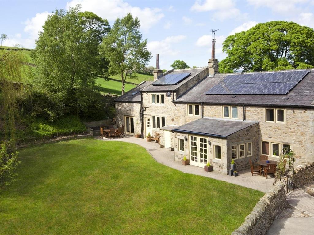 eine Außenansicht eines Hauses mit Sonnenkollektoren auf dem Dach in der Unterkunft Throstle Nest Farm in Carlton