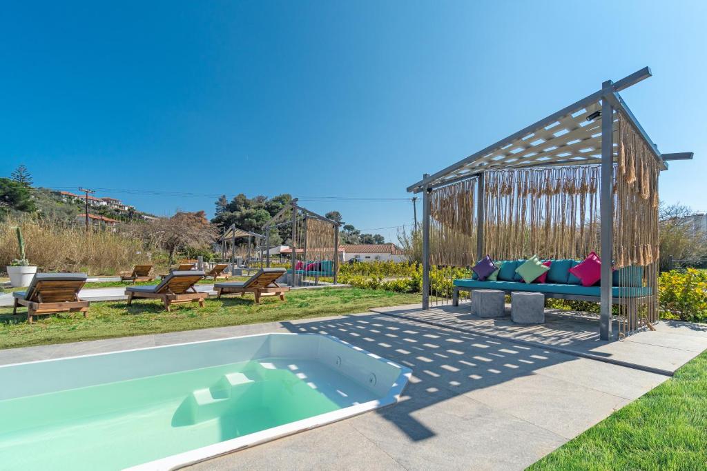 a swimming pool with a bench in a yard at Mythos Luxury Villa-Skiathos in Troulos