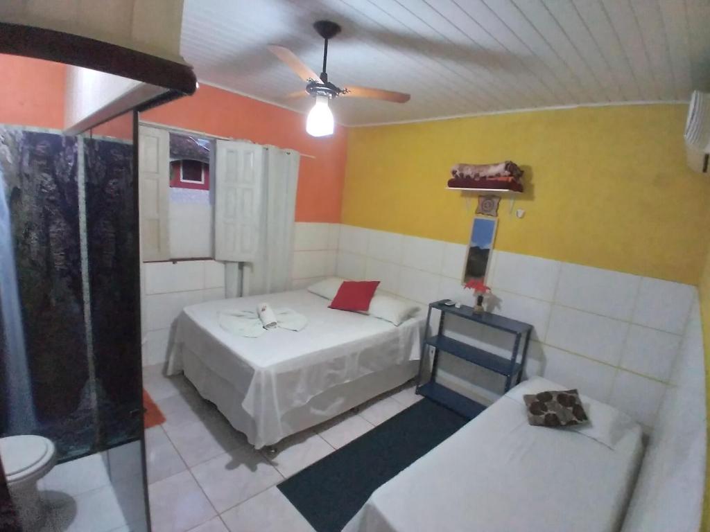 een slaapkamer met 2 bedden en een plafondventilator bij Chapada Casas da Izete in Lençóis