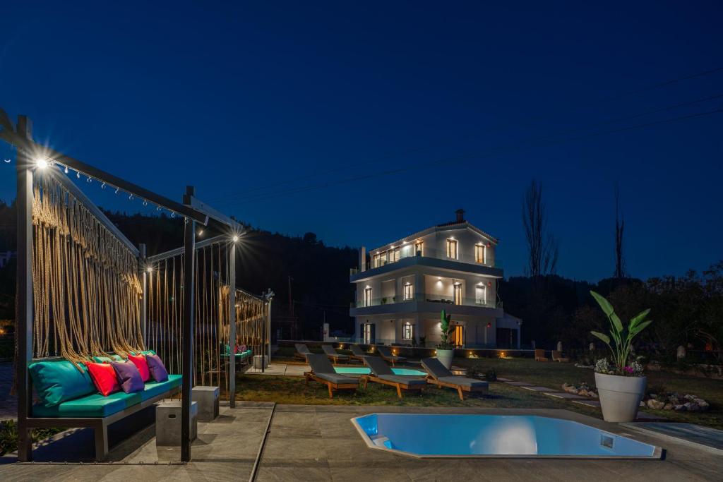 Mythos Luxury Villa-Skiathos في ترولو: منزل أمامه مسبح في الليل